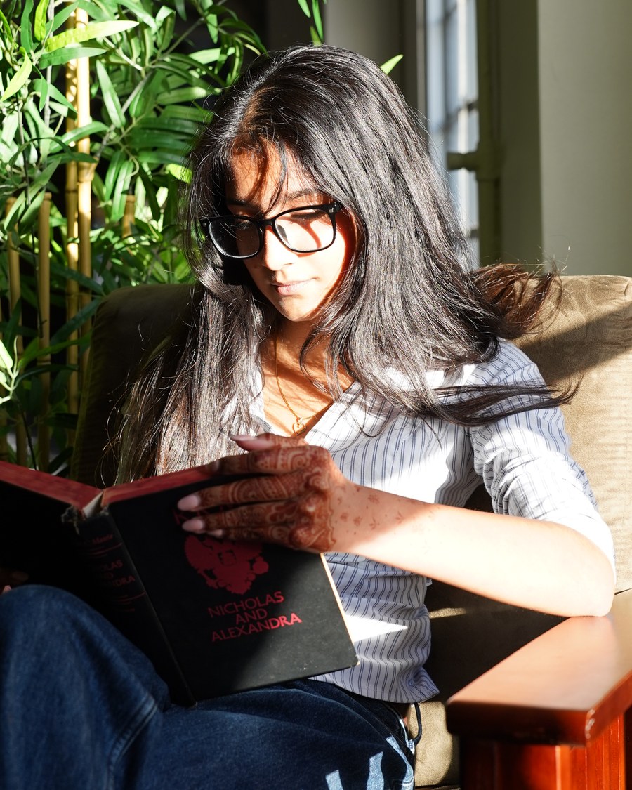 Keisha Rajanish reading in a sunlit room
